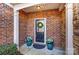 Inviting front entryway featuring a wreath-adorned door, blue planters, and brick accents at 4224 Park South Station Blvd, Charlotte, NC 28210