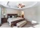 This main bedroom features a tray ceiling with a fan and an attached bathroom at 4224 Park South Station Blvd, Charlotte, NC 28210