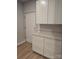 Well-lit laundry area showcasing sleek white cabinetry, stylish countertops, and convenient access to an exterior door at 44389 Us 52 N Hwy, Richfield, NC 28137