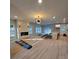 Open-concept living room with light wood floors, fireplace, and modern lighting fixture at 44389 Us 52 N Hwy, Richfield, NC 28137