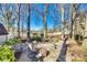Serene backyard featuring a brick patio, gravel areas, and mature trees providing ample shade and privacy at 5011 Tara Tea Dr, Tega Cay, SC 29708