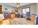 Bright bedroom featuring hardwood floors, a ceiling fan, a large window, and a well-organized desk and workspace at 5011 Tara Tea Dr, Tega Cay, SC 29708