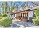 Charming single-story home featuring a quaint front porch, stone chimney, mature landscaping and long driveway at 5011 Tara Tea Dr, Tega Cay, SC 29708