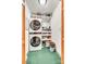 Efficient laundry room with stacked washer and dryer units and built-in shelving for storage at 5011 Tara Tea Dr, Tega Cay, SC 29708