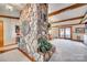 Spacious living room featuring a striking natural stone pillar, exposed beams and access to the outdoor living space at 5011 Tara Tea Dr, Tega Cay, SC 29708