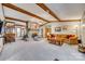 Open-concept living room with exposed beams, stone fireplace, and a cozy seating arrangement at 5011 Tara Tea Dr, Tega Cay, SC 29708