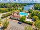 Aerial view of the pool, clubhouse, and parking lot near a lake, surrounded by trees at 5011 Tara Tea Dr, Tega Cay, SC 29708