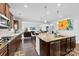 Modern kitchen with stainless steel appliances, hardwood floors, and an open layout leading to living area at 5041 Wakehurst St, Kannapolis, NC 28081