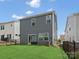 View of back exterior, featuring well-maintained lawn, modern siding, windows, and a sliding glass door at 518 Palmarosa St, Fort Mill, SC 29715
