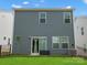 View of the back exterior, with modern gray siding, windows, sliding door, well-maintained lawn, and AC unit at 518 Palmarosa St, Fort Mill, SC 29715