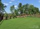 Spacious backyard with lush green grass, surrounded by a black metal fence and a wooden playset at 518 Palmarosa St, Fort Mill, SC 29715