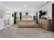 Large primary bedroom with neutral colored walls, plush carpet, luxury furniture, and plenty of natural light at 518 Palmarosa St, Fort Mill, SC 29715