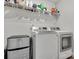 Well-equipped laundry room features washer, dryer, shelving and mini-fridge for added convenience at 518 Palmarosa St, Fort Mill, SC 29715