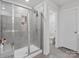 Modern walk-in shower with gray tiling, a shower bench, and convenient toiletry shelving at 518 Palmarosa St, Fort Mill, SC 29715