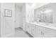 Modern bathroom with double sink vanity, white cabinets, large mirror, and tile flooring at 5367 Turtle Creek Dr, Denver, NC 28037