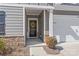Charming front entrance with gray siding, black door with a yellow flower wreath, and a two-car garage on the right at 5367 Turtle Creek Dr, Denver, NC 28037