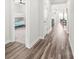 Bright hallway featuring modern gray wood flooring, leading to a bedroom and dining area at 5367 Turtle Creek Dr, Denver, NC 28037