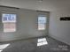 Neutral bedroom with gray carpet, light gray walls, two windows, and modern fixtures at 609 Grandiflora Ave, Lancaster, SC 29720