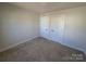 Simple bedroom with gray carpet, light gray walls, and two white doors at 609 Grandiflora Ave, Lancaster, SC 29720