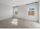A carpeted bedroom with gray walls, two windows, and a view of the backyard at 609 Grandiflora Ave, Lancaster, SC 29720