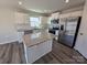 Bright kitchen with white cabinets, stainless steel appliances, kitchen island, and modern flooring at 609 Grandiflora Ave, Lancaster, SC 29720