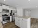 Bright kitchen featuring a center island, stainless steel appliances, granite countertops, and wood-look floors at 609 Grandiflora Ave, Lancaster, SC 29720