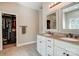 Well-lit bathroom with double vanity, white cabinetry, and a walk-in closet at 6618 Alexander Rd, Charlotte, NC 28270