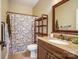 Bathroom with a granite countertop, shower with floral curtain and wood shelf at 6618 Alexander Rd, Charlotte, NC 28270