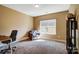 Home office featuring a neutral color scheme with a gray chair, modern desk, and bright natural light at 6618 Alexander Rd, Charlotte, NC 28270