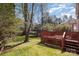 Lush green backyard with mature trees, partially enclosed by a red lattice fence at 7533 Lady Bank Dr, Charlotte, NC 28269