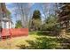 Expansive backyard with green lawn, mature trees, and a red lattice-style fence at 7533 Lady Bank Dr, Charlotte, NC 28269