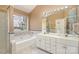 Primary bathroom featuring double sinks, soaking tub, and a large window at 7533 Lady Bank Dr, Charlotte, NC 28269