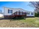 View of the home's vinyl siding, brick foundation and wooden deck in the backyard at 7536 Beaver Rd, Kannapolis, NC 28081