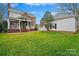 Expansive backyard with lush green lawn, mature trees, and patio connecting to the house at 7704 Sharpthorne Pl, Charlotte, NC 28270