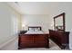 Comfortable bedroom with a sleigh bed, shuttered window, and matching furniture set at 7704 Sharpthorne Pl, Charlotte, NC 28270