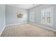 Spacious bedroom with ample natural light from two shuttered windows, light blue paint, and carpet at 7704 Sharpthorne Pl, Charlotte, NC 28270