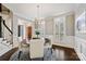 Well-lit dining room with modern chandelier, neutral walls, and hardwood floors near the staircase and entry at 7704 Sharpthorne Pl, Charlotte, NC 28270