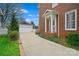 Long driveway leads to a detached garage, complemented by the home's brick facade at 7704 Sharpthorne Pl, Charlotte, NC 28270