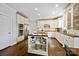 An open kitchen features white cabinets, stainless appliances, hardwood floors, and a butcher block island at 7704 Sharpthorne Pl, Charlotte, NC 28270