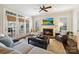 Cozy living room with fireplace, plush seating, and ample natural light from large windows and french doors at 7704 Sharpthorne Pl, Charlotte, NC 28270