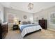 A primary bedroom boasts carpet, two dressers, accent lighting, and a king bed with decorative pillows at 7704 Sharpthorne Pl, Charlotte, NC 28270