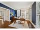 A home office features a built-in bookshelf, a wooden desk, and wainscoting along the navy blue walls at 7704 Sharpthorne Pl, Charlotte, NC 28270