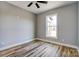 A bright bedroom features light gray walls, wood-look floors, ceiling fan and a window at 805 Tirzah Rd, York, SC 29745