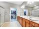 Bathroom featuring a double vanity, framed mirrors, and a glass-enclosed shower, with a walk-in closet at 9005 Smokey Hill Ln, Indian Land, SC 29707