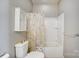 Bright bathroom featuring a toilet, tub/shower with a patterned curtain, and cabinet storage at 9005 Smokey Hill Ln, Indian Land, SC 29707