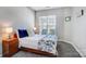 Cozy bedroom with ample natural light from the window, featuring bedside tables and blue floral bedding at 9005 Smokey Hill Ln, Indian Land, SC 29707