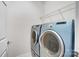 Laundry room featuring a pair of front-load Samsung washers and dryers with a metal shelf above at 9005 Smokey Hill Ln, Indian Land, SC 29707