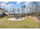 Backyard featuring a fire pit area, lush lawn, and mature trees at 9260 Ahavah Ln, Indian Trail, NC 28079