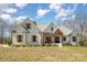 A charming white brick house with a manicured lawn, dark window frames, and wooden shutters under a blue sky at 9260 Ahavah Ln, Indian Trail, NC 28079