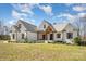 A charming white brick house with a manicured lawn, dark window frames, and wooden shutters under a blue sky at 9260 Ahavah Ln, Indian Trail, NC 28079